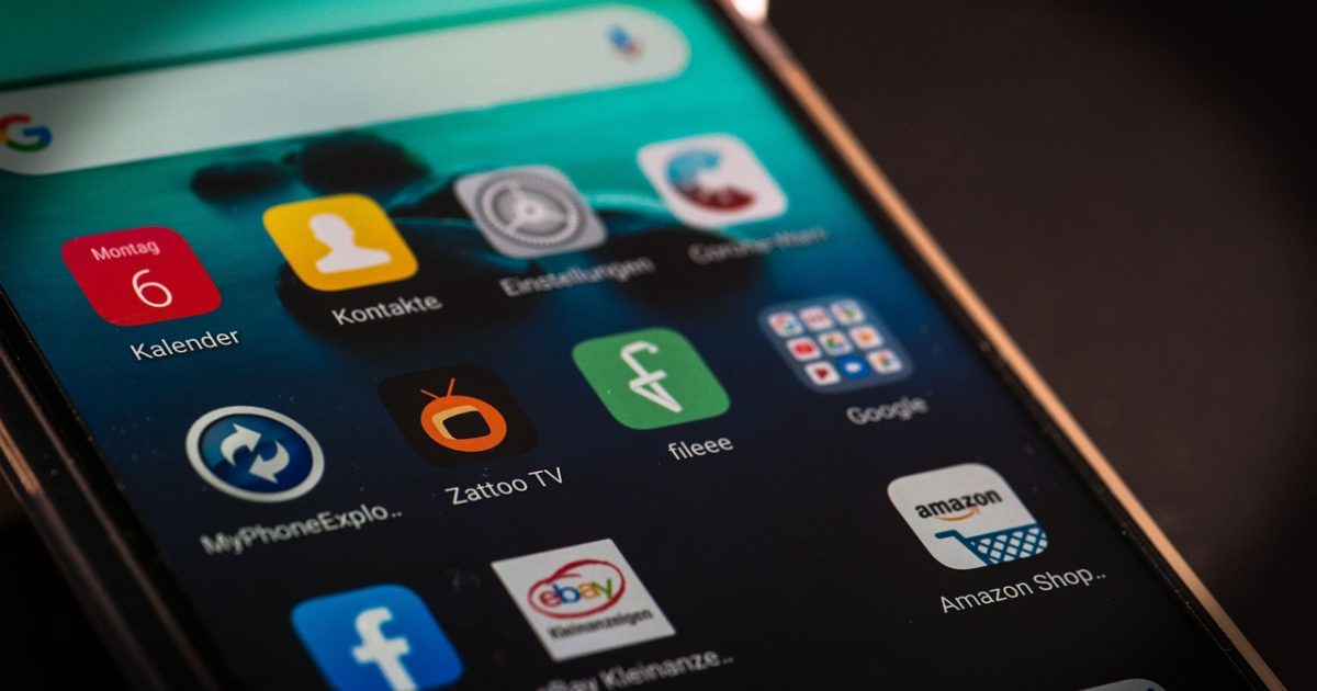 pdf转换器 App 主界面在手机屏幕上的展示，浅粉背景中一份 PDF 文档正被拖入玫红色转换按钮，旁边浮着 Word 与图片格式图标，整体氛围轻快明亮